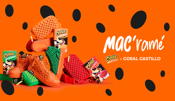 The collection of CHEETOS Mac ‘N Cheese x Coral Castillo items, including red, orange, and green high-top sneakers and red, orange and green Fanny MAC bags piled on top of each other in bold fashion.  